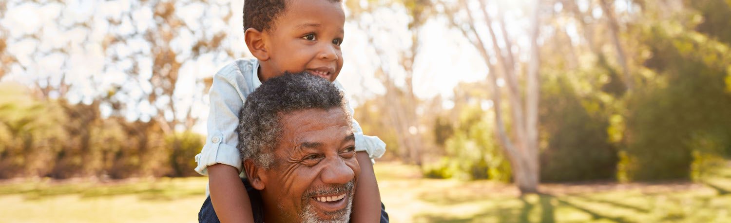 older man with child on shoulders